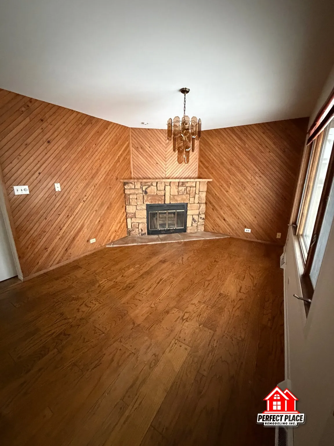 Family room — refinished hardwood around a stone fireplace