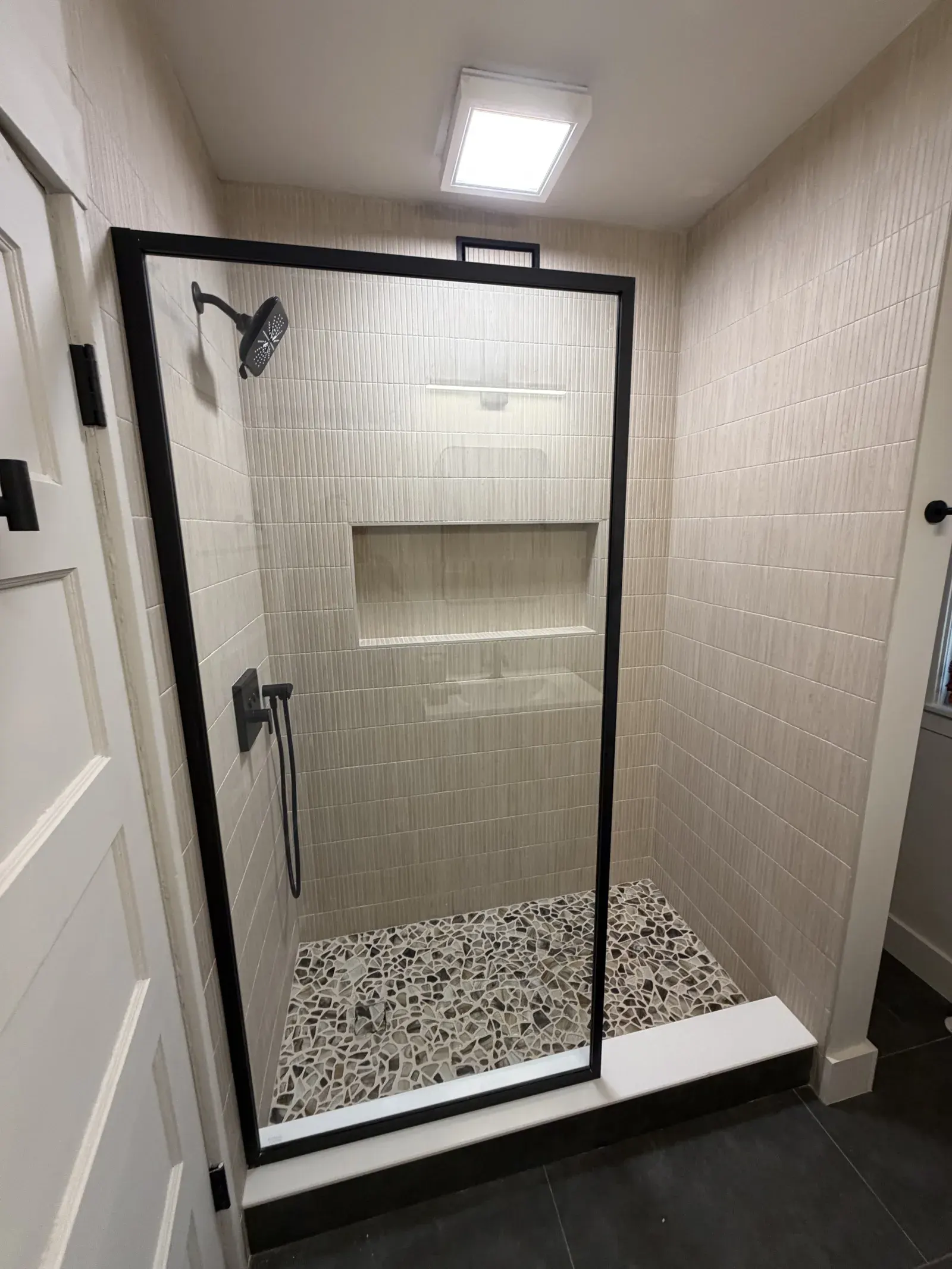 Shower detail — matte-black rain set and built-in niche
