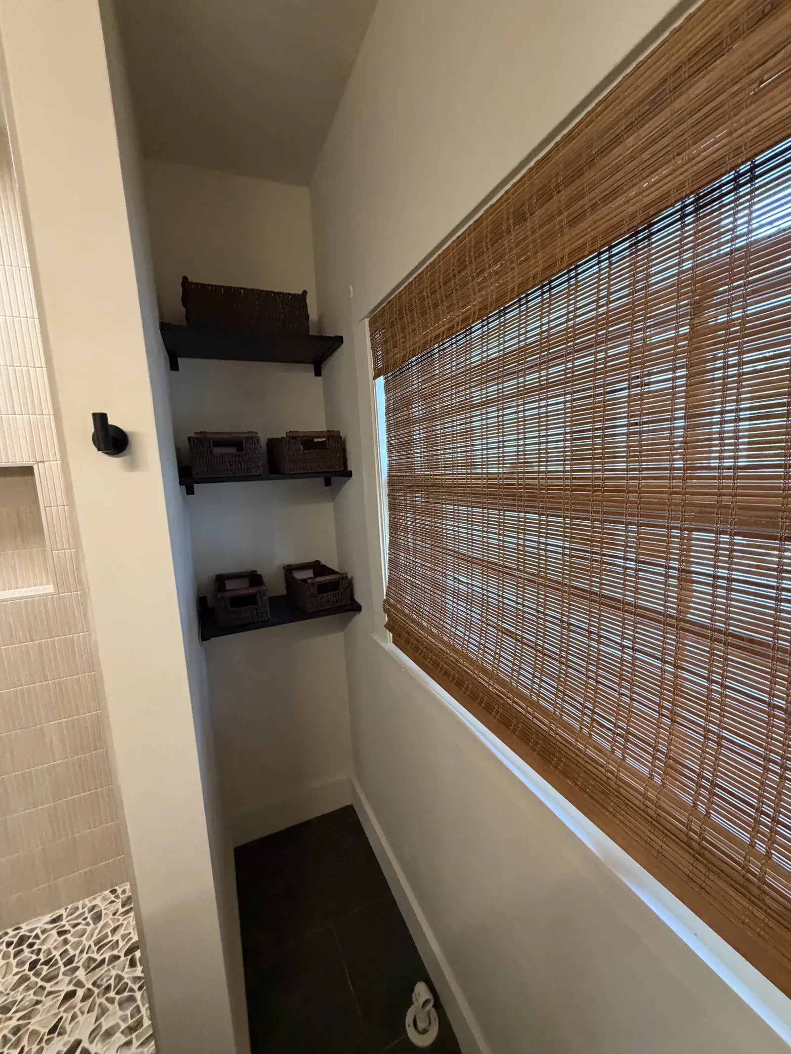 Storage nook with floating shelves and woven shade