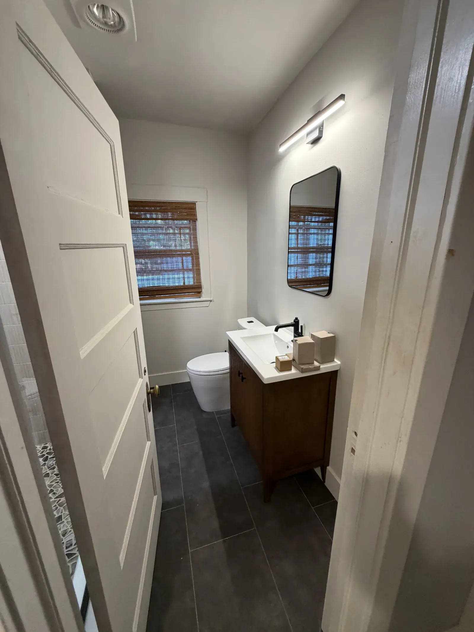 Hall bath remodel — new vanity, tile floor, and lighting